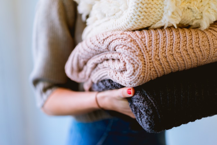 「Instagramの秋の写真のアイデア-折り畳まれたセーターを手に持った女の子」